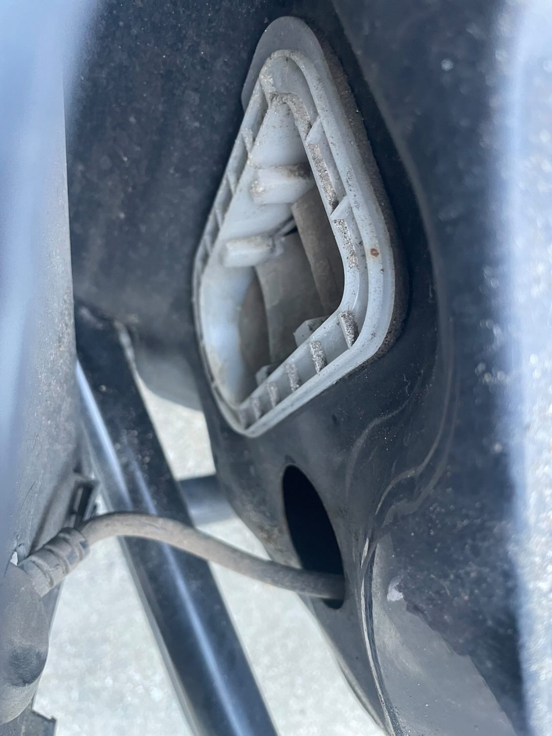 OEM vent located behind bumper, notice the rubber flaps. they are the main access point of dust, dirt debris, and even mice. It opens right into the cabin and collects behind interior panels and pollutes the cabin.
